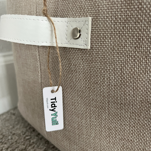 Close-up of TidyYuli basket cotton-linen fabric and faux leather handle tag